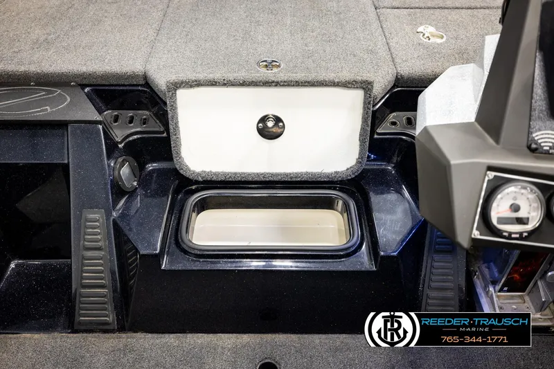 Slide: The Image of 2023 Ranger Z519 boat interior with storage compartment and control panel, Reeder-Trausch Marine branding. - 22
