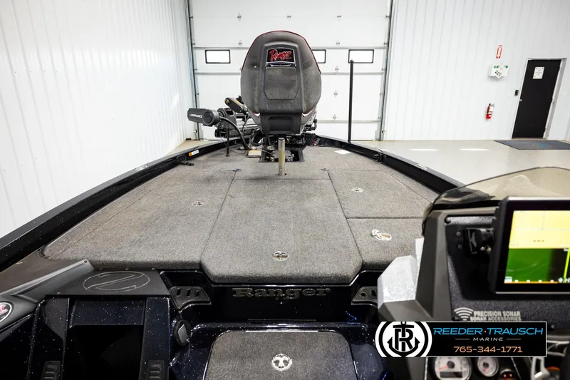 Slide: The Image of 2023 Ranger Z519 boat interior with fishing seat and navigation equipment in a garage. - 23