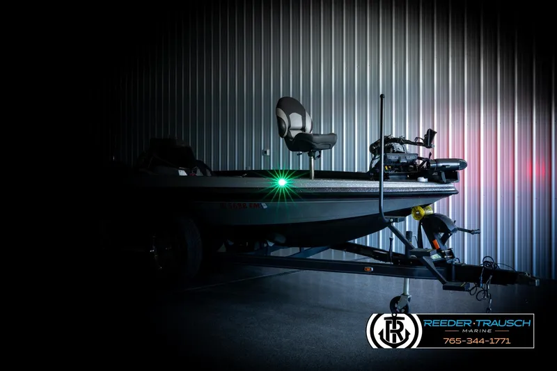 Slide: The Image of 2023 Ranger Z519 boat in a dimly lit garage with Reeder-Trausch Marine branding. - 3