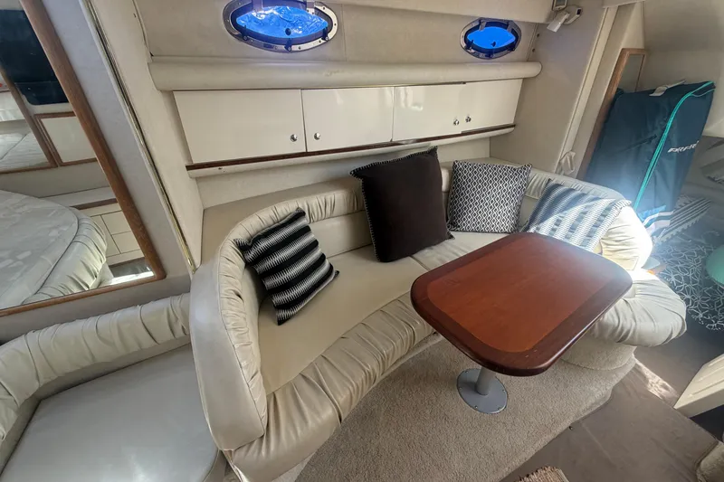 Slide: The Image of Interior of 1997 Sea Ray Sundancer 330 with cozy seating and wooden table. - 10