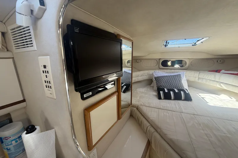 Slide: The Image of Interior of 1997 Sea Ray Sundancer 330 with bed, TV, and porthole windows. - 12