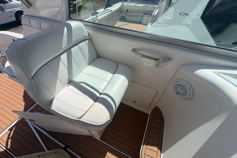 Slide: The Image of 1997 Sea Ray Sundancer 330 interior with white seating and teak flooring. - 13
