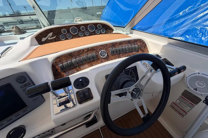 Slide: The Image of 1997 Sea Ray Sundancer 330 helm with steering wheel, controls, and instrument panel. - 19