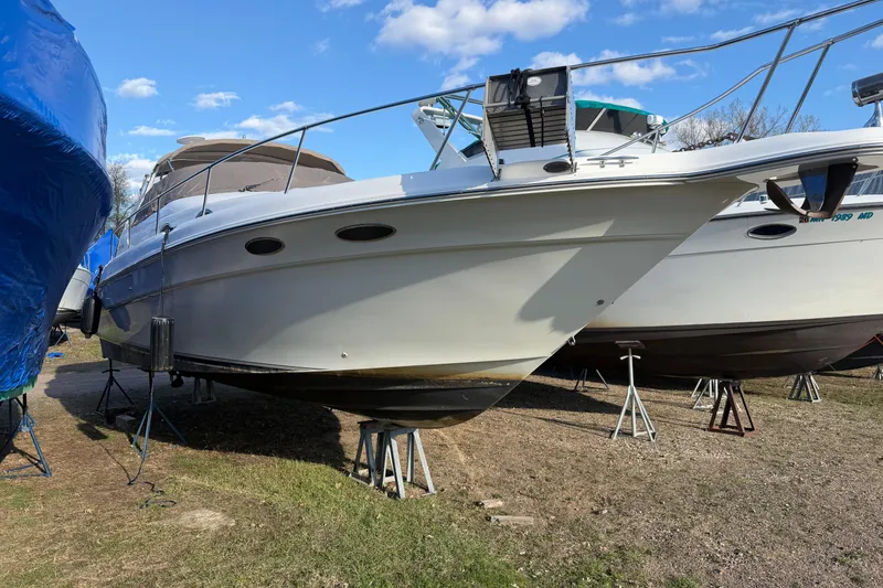 Slide: The Image of 1997 Sea Ray Sundancer 330 yacht on stands, ready for maintenance under a clear sky. - 2