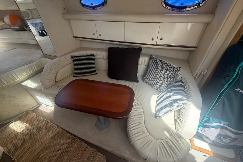 Slide: The Image of Interior of a 1997 Sea Ray Sundancer 330 with cozy seating and decorative pillows. - 6