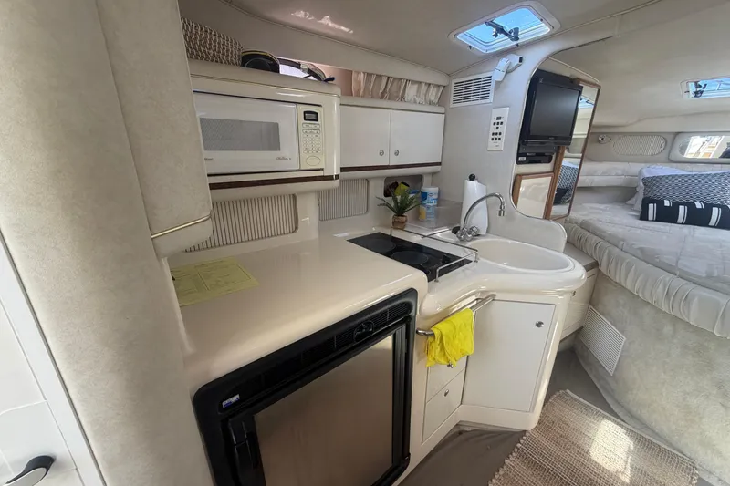 Slide: The Image of Interior of a 1997 Sea Ray Sundancer 330 yacht with kitchenette and cozy sleeping area. - 7