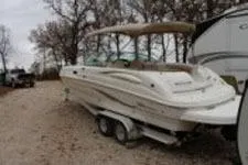 Slide: The Image of 2002 Chaparral Sunesta 263 boat on trailer, parked outdoors near trees. - 2
