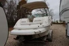 Slide: The Image of 2002 Chaparral Sunesta 263 boat with canopy, parked on gravel, surrounded by trees. - 5