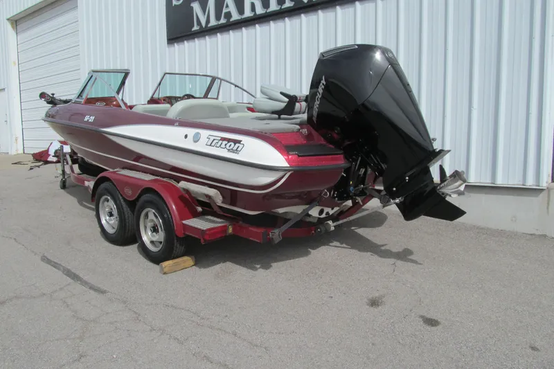 Slide: The Image of 2000 Triton SF-21 boat on trailer, parked outside a building. - 3