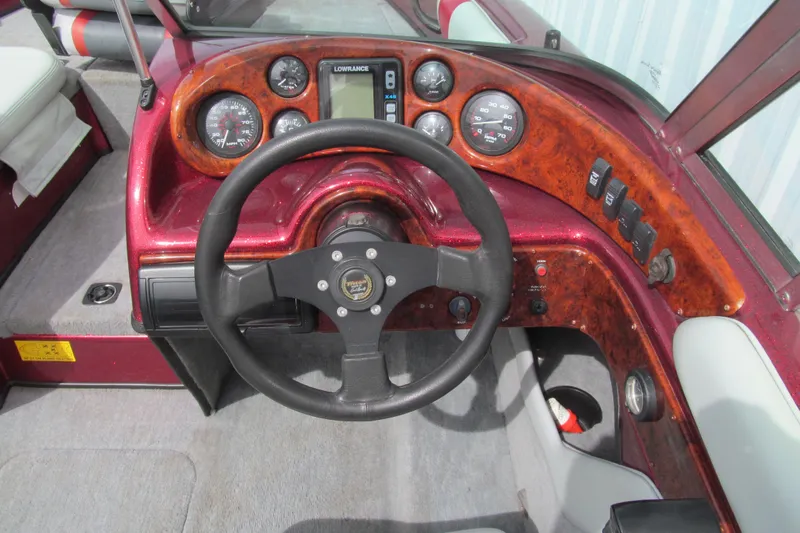 Slide: The Image of Steering wheel and dashboard of a 2000 Triton SF-21 boat with wood accents. - 7