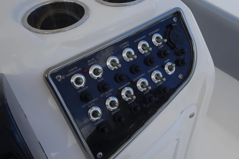 Slide: The Image of Control panel of 2022 NauticStar 2302 Legacy boat with labeled switches. - 16