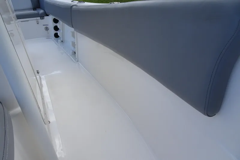 Slide: The Image of 2022 NauticStar 2302 Legacy boat interior with gray seating and white deck. - 19