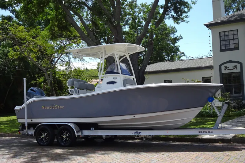 Slide: The Image of 2022 NauticStar 2302 Legacy boat on trailer, parked in residential area. - 23