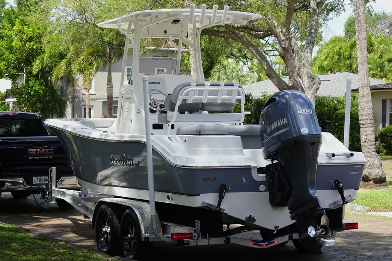 Slide: The Image of 2022 NauticStar 2302 Legacy boat on trailer with Yamaha engine, parked outdoors. - 3