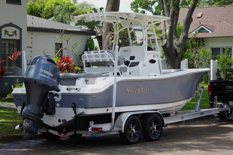 Slide: The Image of 2022 NauticStar 2302 Legacy boat on trailer, parked in residential area. - 7