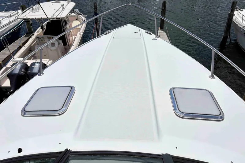 Slide: The Image of 2008 Formula 310 Sun Sport boat docked, showcasing sleek deck design and water surroundings. - 12