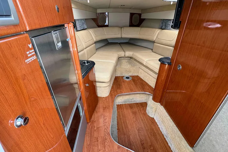 Slide: The Image of Interior of 2008 Formula 310 Sun Sport boat with wood finish and beige seating. - 13