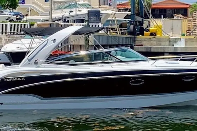 Slide: The Image of 2008 Formula 310 Sun Sport boat docked in marina, featuring sleek design and black canopy. - 2