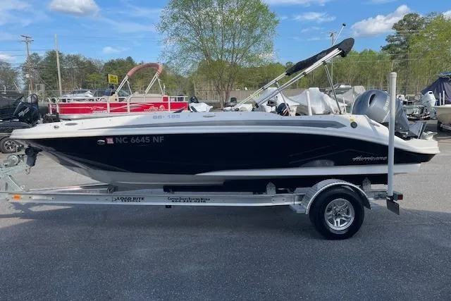 Slide: The Image of 2023 Hurricane SunDeck Sport 185 OB boat on trailer, parked outdoors. - 2