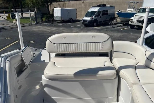 Slide: The Image of 2005 Crownline 240 EX boat interior with white seating in a parking lot setting. - 15