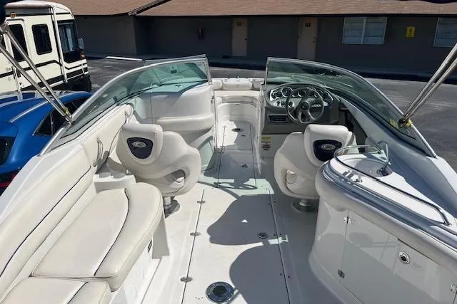 Slide: The Image of 2005 Crownline 240 EX boat interior with white seating and steering console. - 18