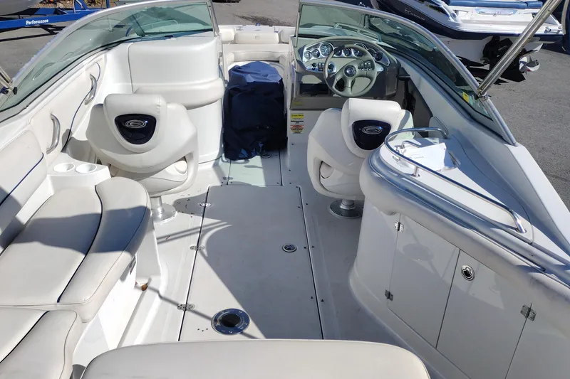 Slide: The Image of 2005 Crownline 240 EX boat interior with white seating and steering console. - 20