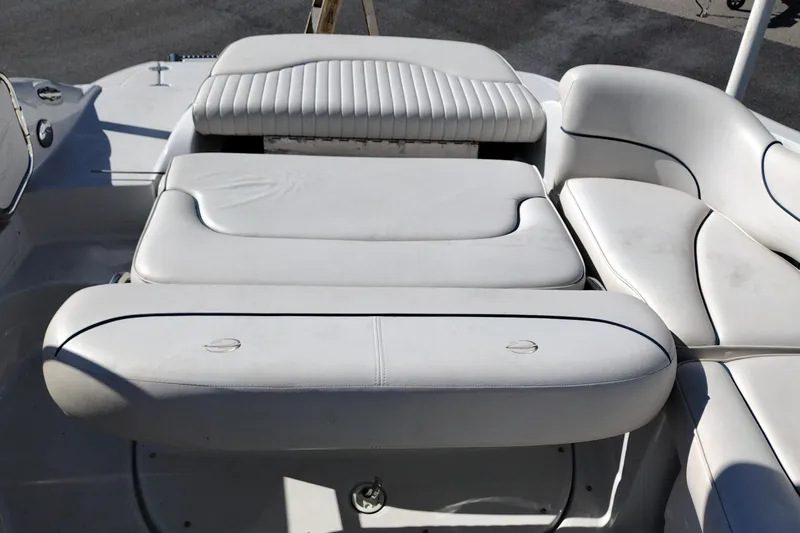 Slide: The Image of 2005 Crownline 240 EX boat interior with white cushioned seating and sun pad. - 31