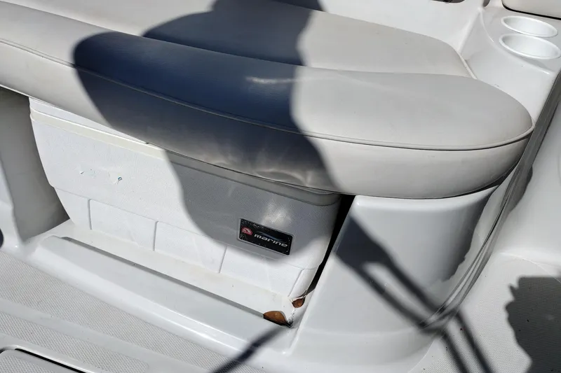Slide: The Image of 2005 Crownline 240 EX boat interior with white seating and storage compartment. - 34