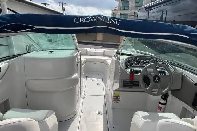 Slide: The Image of 2005 Crownline 240 EX boat interior with steering wheel and seating area. - 37