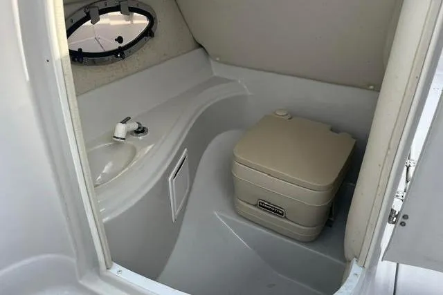 Slide: The Image of 2005 Crownline 240 EX boat interior with sink and portable toilet. - 39