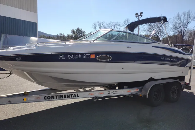 Slide: The Image of 2005 Crownline 240 EX boat on trailer, parked outdoors, with visible registration number. - 4