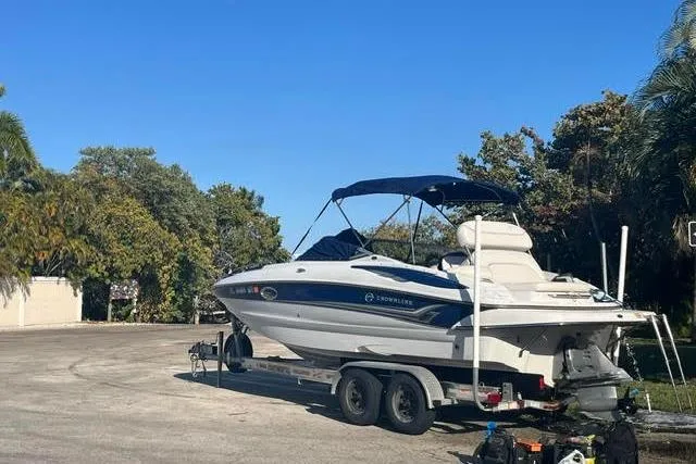Slide: The Image of 2005 Crownline 240 EX boat on trailer, parked outdoors under clear blue sky. - 44