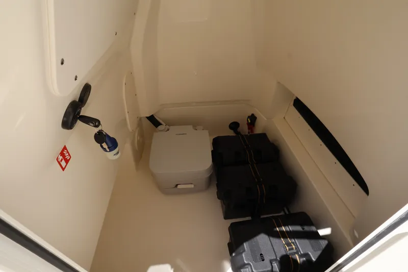 Slide: The Image of Interior of a Boston Whaler 250 Dauntless with storage space and a portable toilet. - 24