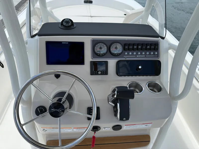 Slide: The Image of The image shows the helm of a Boston Whaler 210 Montauk with a steering wheel, gauges, and controls. - 18