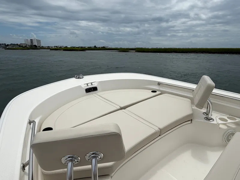 Slide: The Image of The image shows the bow of a Boston Whaler 210 Montauk with beige cushions and a cloudy sky. - 23