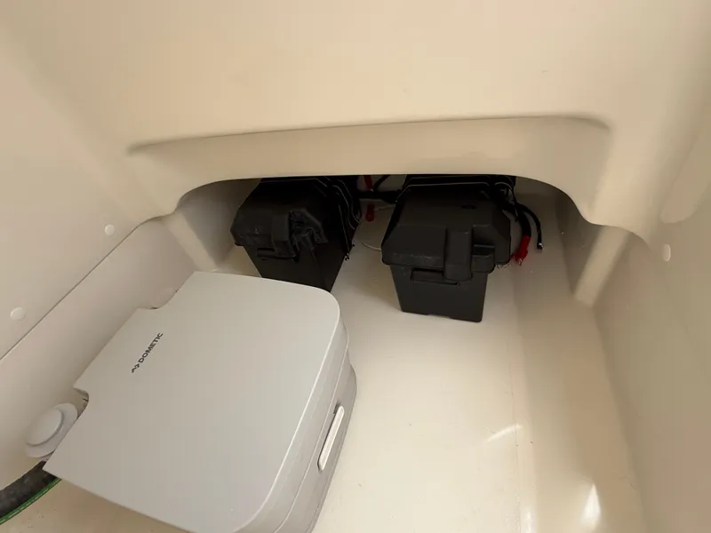 Slide: The Image of Interior view of a Boston Whaler 210 Montauk with two black battery boxes and a portable toilet. - 15