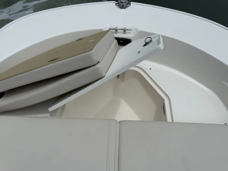 Slide: The Image of The 2026 Boston Whaler 210 Montauk features an open storage compartment with cushioned seating. - 22