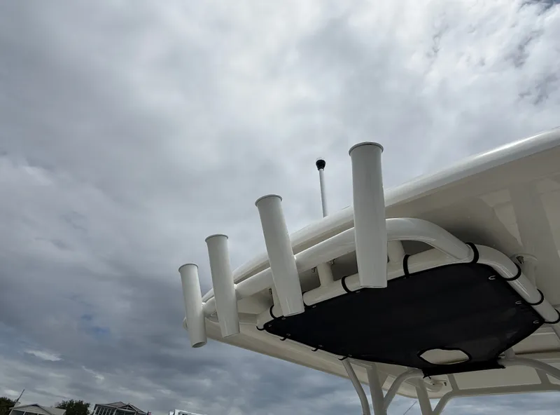 Slide: The Image of View of the fishing rod holders and roof of a 2026 Boston Whaler 210 Montauk under a cloudy sky. - 19