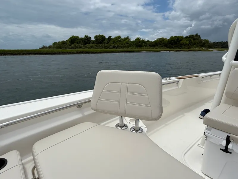 Slide: The Image of The image shows the interior of a Boston Whaler 210 Montauk boat with beige seats and a river in the background. - 21