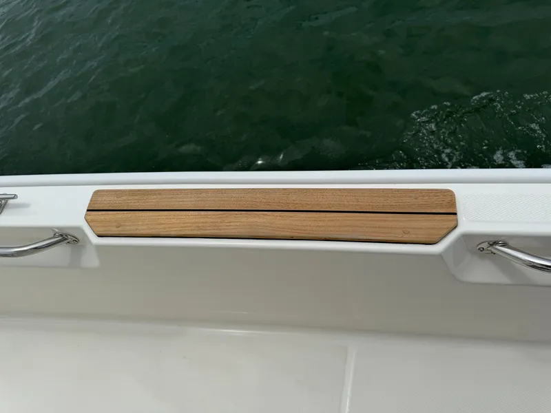 Slide: The Image of A teak detail on the deck of a Boston Whaler 210 Montauk boat, surrounded by water. - 16