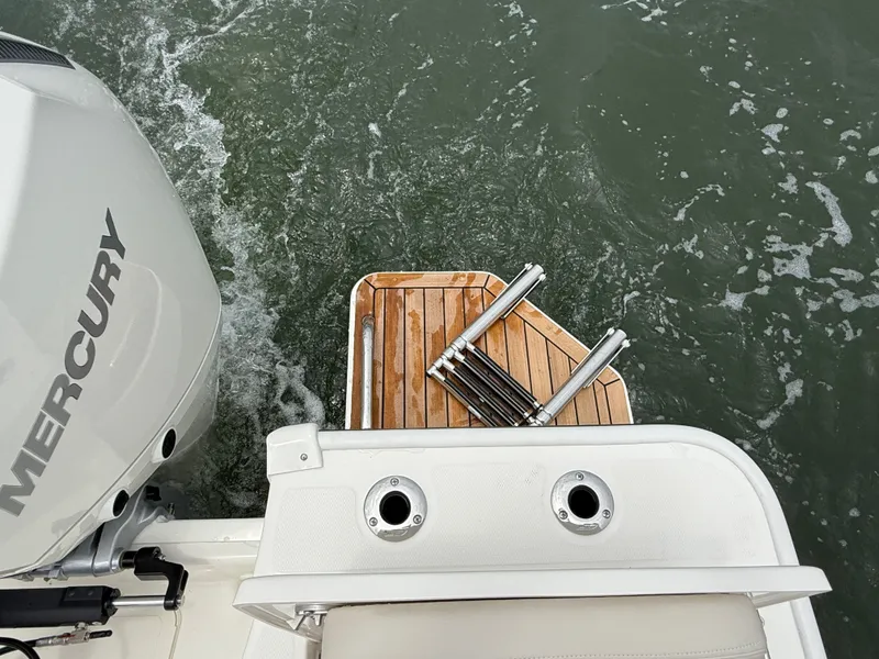 Slide: The Image of The image shows the stern of a Boston Whaler 210 Montauk with a Mercury engine and wooden platform. - 9