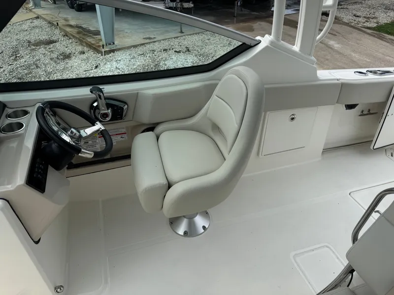 Slide: The Image of The helm of a 2027 Boston Whaler 240 Vantage with a cushioned captain's chair. - 16