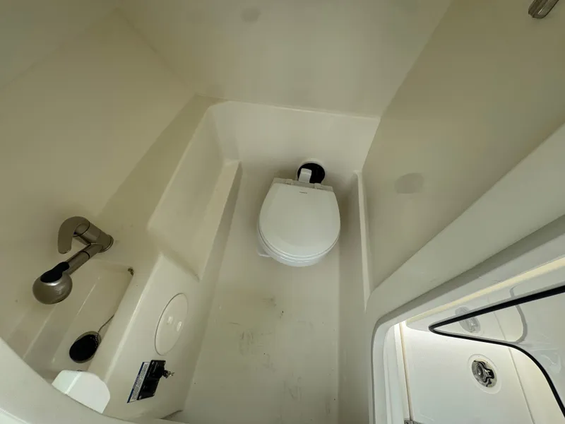 Slide: The Image of The cabin of the 2027 Boston Whaler 240 Vantage features a compact toilet and sink. - 15
