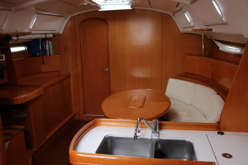 Slide: The Image of Interior of 2005 Beneteau First 47.7 yacht with wooden cabinetry and cozy seating area. - 11