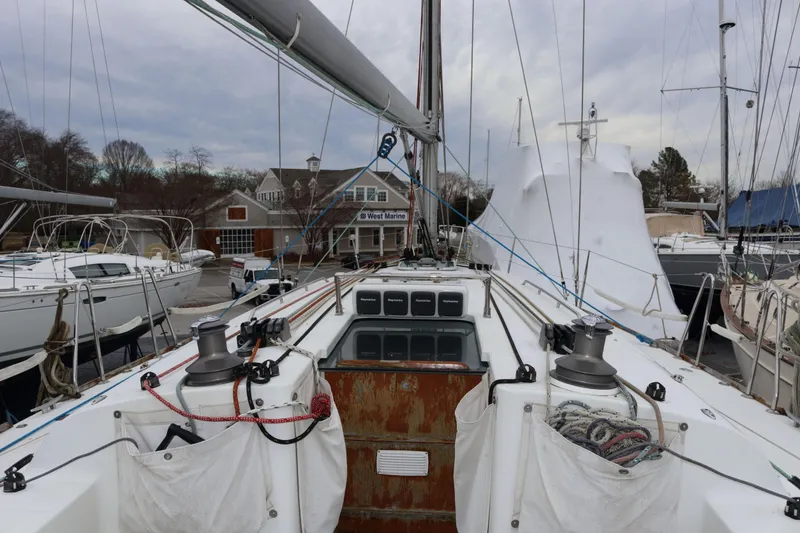 Slide: The Image of 2005 Beneteau First 47.7 sailboat docked at marina, showcasing deck and winches. - 2