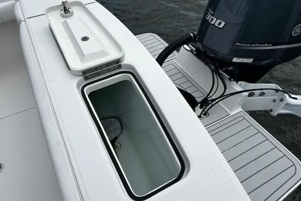 Slide: The Image of 2018 Regulator 23 Forward Seating boat with open storage compartment and Yamaha 300 engine. - 12