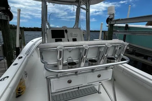 Slide: The Image of 2018 Regulator 23 Forward Seating boat with rod holders and console, docked by the water. - 15