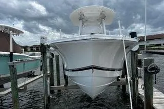 Slide: The Image of 2018 Regulator 23 Forward Seating boat docked under cloudy skies. - 2
