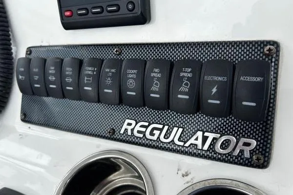 Slide: The Image of Control panel of 2018 Regulator 23 Forward Seating boat with labeled switches. - 23