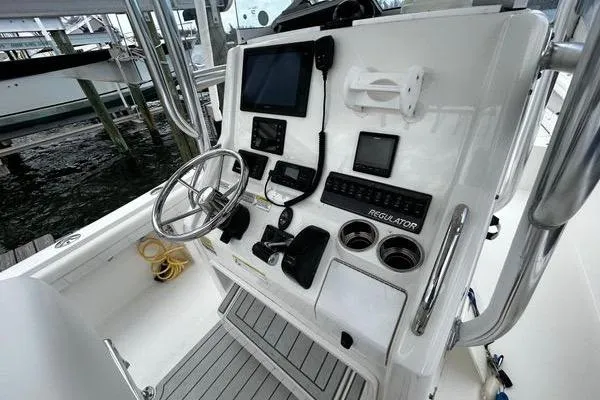 Slide: The Image of 2018 Regulator 23 Forward Seating boat console with steering wheel and navigation equipment. - 24